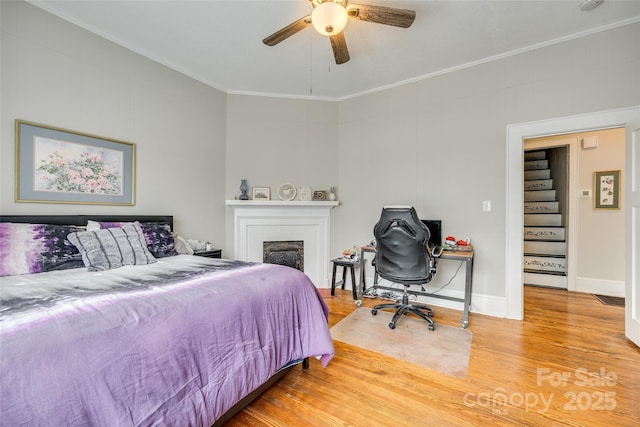 bedroom featuring hardwood / wood-style flooring, crown molding, and ceiling fan
