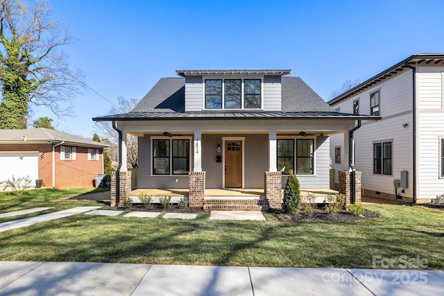 view of front of house featuring covered porch, a front lawn, a standing seam roof, and a ceiling fan