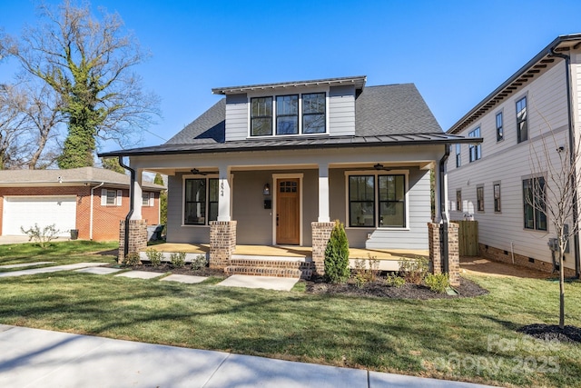 view of front of house with a front lawn, a standing seam roof, a porch, roof with shingles, and metal roof