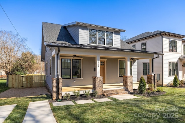 view of front of property featuring a porch, a front yard, roof with shingles, and ceiling fan