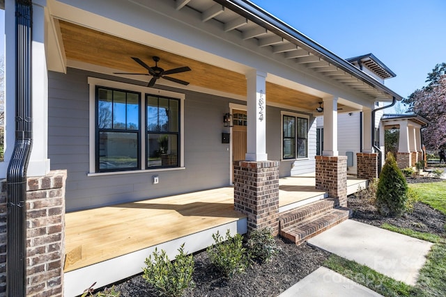 property entrance with brick siding, a porch, and a ceiling fan