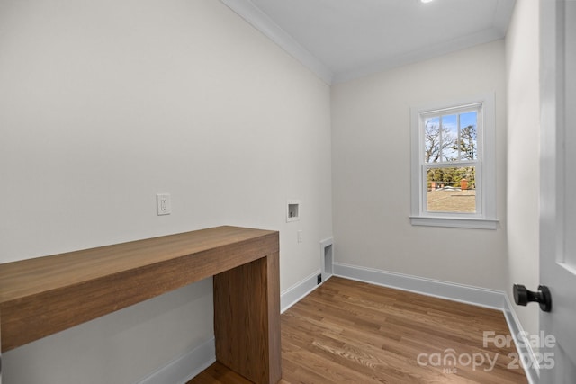 clothes washing area with wood finished floors, hookup for a washing machine, laundry area, and crown molding