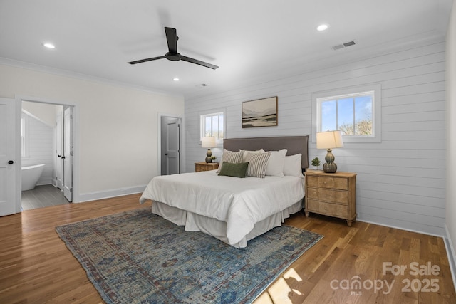 bedroom with multiple windows, wood finished floors, and visible vents