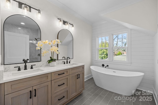 full bath with a sink, a freestanding tub, tiled shower, and double vanity