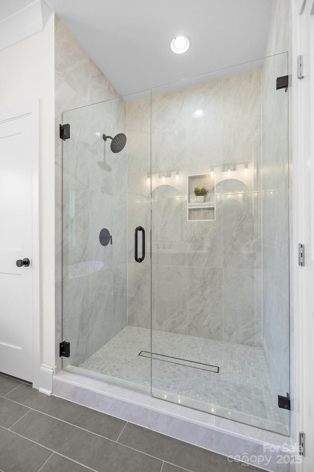 bathroom featuring tile patterned flooring and a shower stall