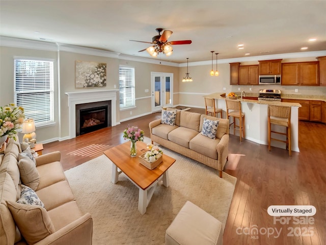 living room featuring hardwood / wood-style flooring, ceiling fan, and ornamental molding