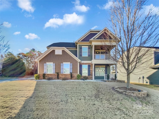 view of front of home featuring a front yard and a balcony