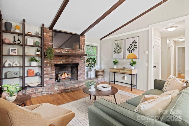 living room featuring a fireplace, light hardwood / wood-style flooring, and lofted ceiling with beams