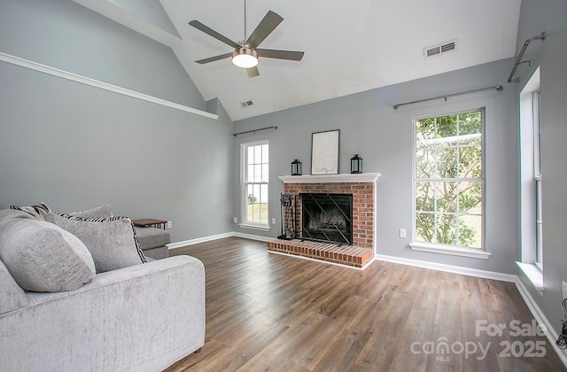 living room with ceiling fan, a brick fireplace, hardwood / wood-style floors, and high vaulted ceiling