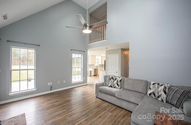 living room featuring hardwood / wood-style floors, high vaulted ceiling, and ceiling fan