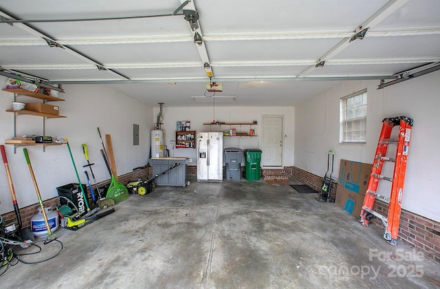 garage with a garage door opener, gas water heater, electric panel, and stainless steel fridge