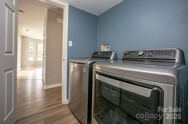 clothes washing area featuring light hardwood / wood-style flooring and independent washer and dryer