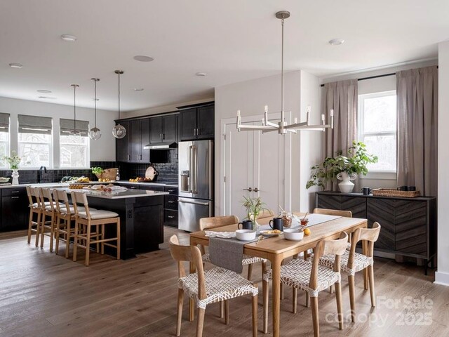 dining space with light wood-style flooring and an inviting chandelier
