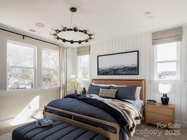bedroom featuring visible vents and a notable chandelier