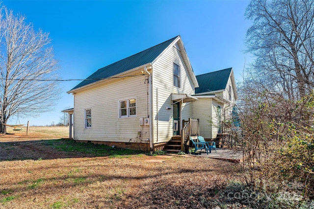 view of home's exterior featuring metal roof, crawl space, and a patio