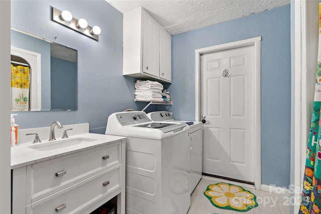 clothes washing area with a textured ceiling, light tile patterned flooring, a sink, cabinet space, and washing machine and clothes dryer