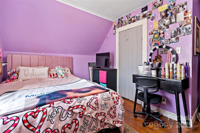 bedroom with lofted ceiling, a closet, and wood finished floors