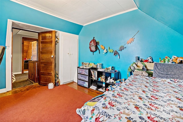 bedroom featuring vaulted ceiling, ornamental molding, and wood finished floors