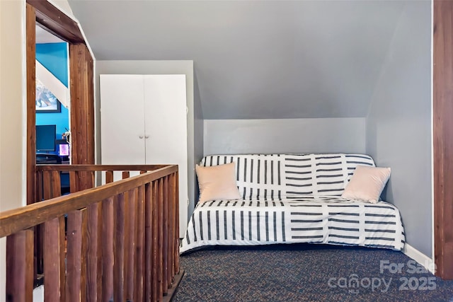 carpeted bedroom featuring lofted ceiling and baseboards