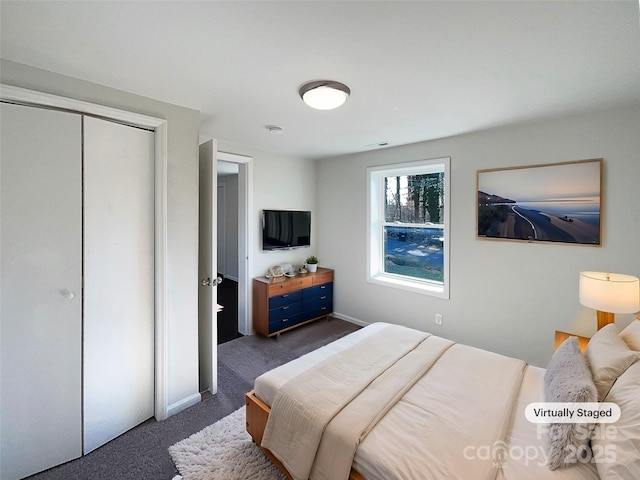 bedroom with dark colored carpet and a closet