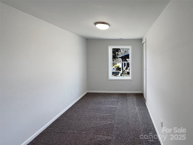 unfurnished room with dark colored carpet