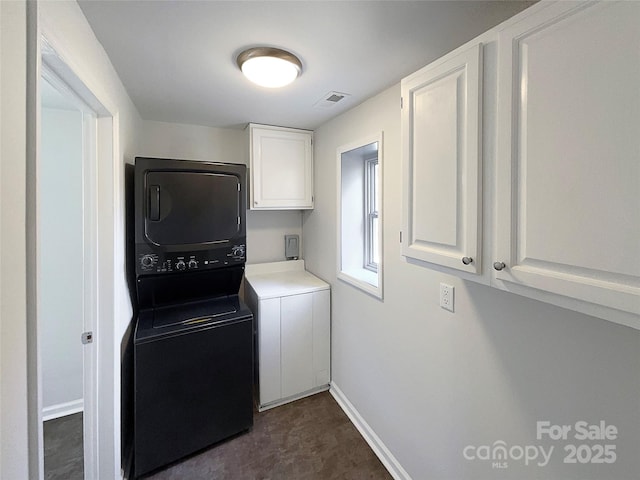 kitchen with white cabinets and stacked washing maching and dryer