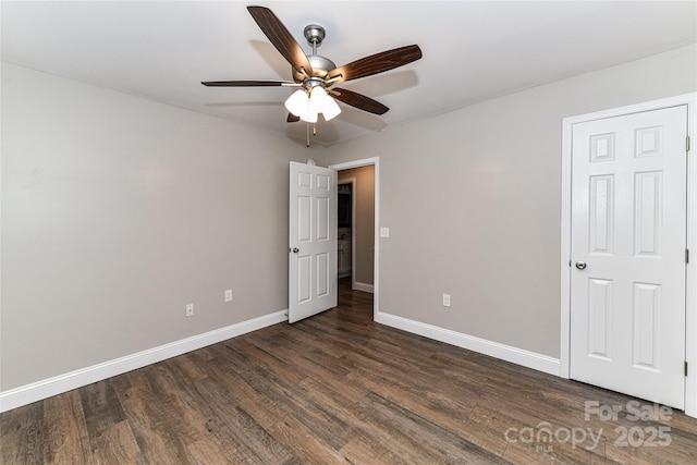 unfurnished bedroom featuring ceiling fan, dark wood-type flooring, and baseboards