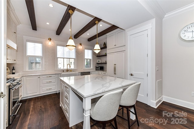 kitchen with pendant lighting, stainless steel appliances, a center island, and white cabinets