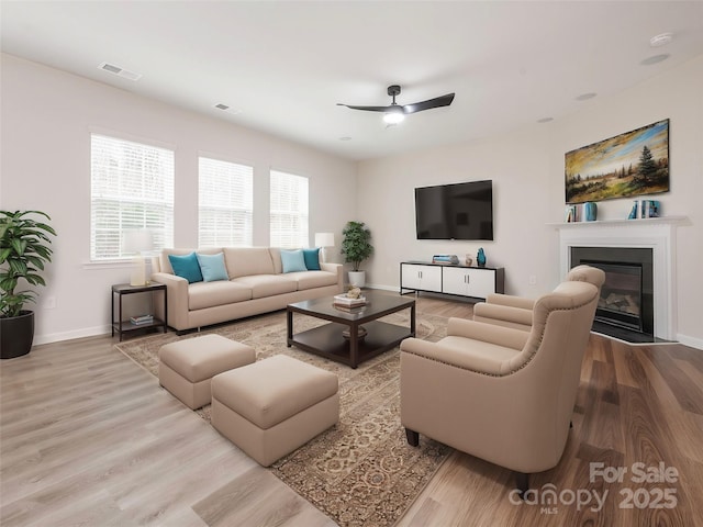 living room featuring light hardwood / wood-style flooring and ceiling fan