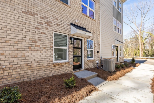 property entrance with central AC and brick siding