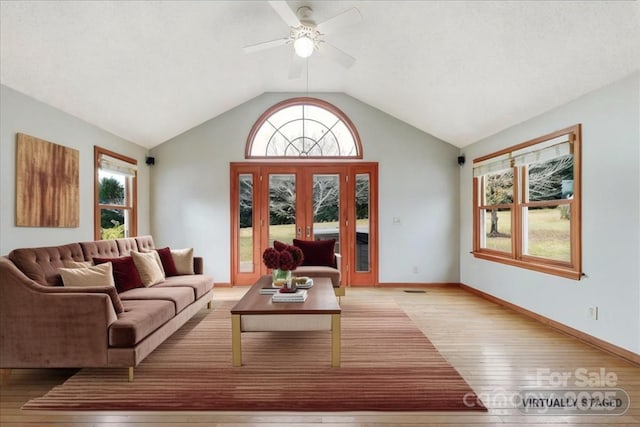 living room with ceiling fan, vaulted ceiling, and light wood-type flooring