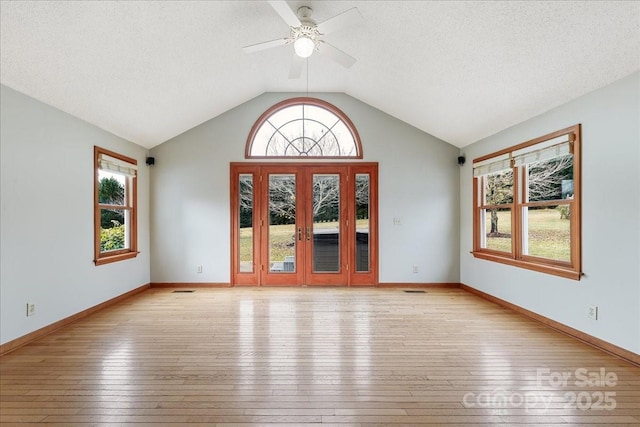 interior space with vaulted ceiling, light hardwood / wood-style floors, and a textured ceiling