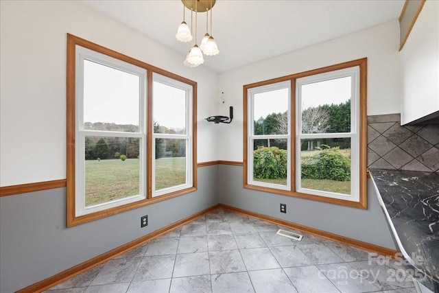 unfurnished dining area featuring a chandelier