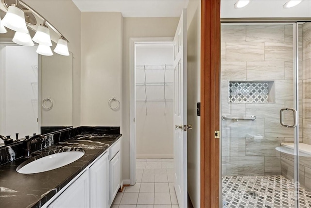 bathroom featuring tile patterned flooring, vanity, and a shower with shower door