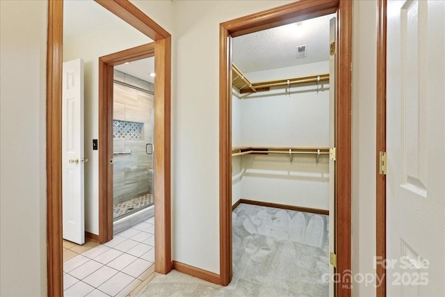 hall featuring light colored carpet and a textured ceiling