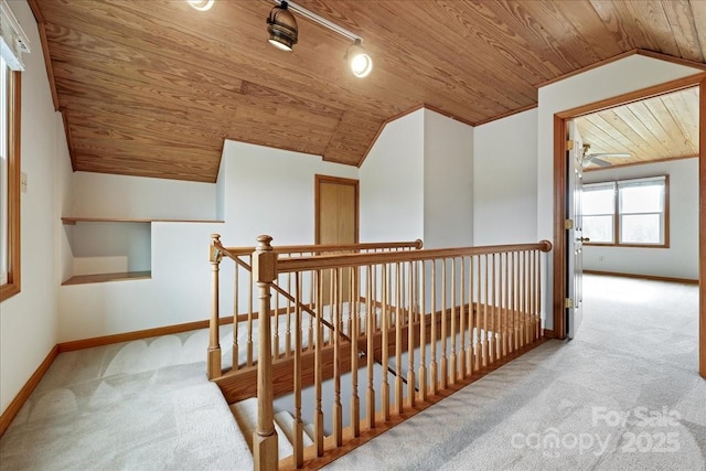 hallway with lofted ceiling, wood ceiling, and light colored carpet