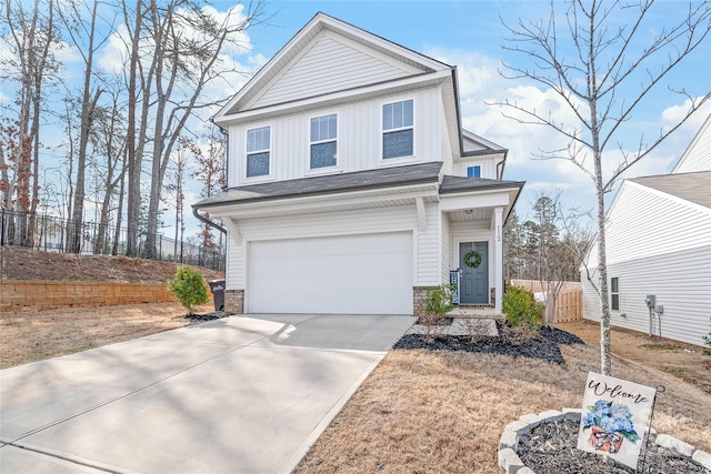 traditional-style house featuring board and batten siding, concrete driveway, fence, and a garage