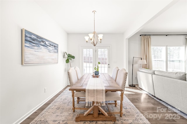 dining room featuring baseboards, a chandelier, and dark wood-type flooring