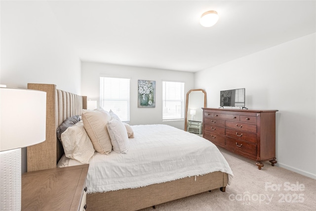 bedroom featuring light carpet and baseboards