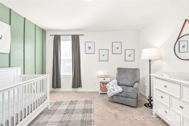 bedroom with light colored carpet, a crib, and baseboards