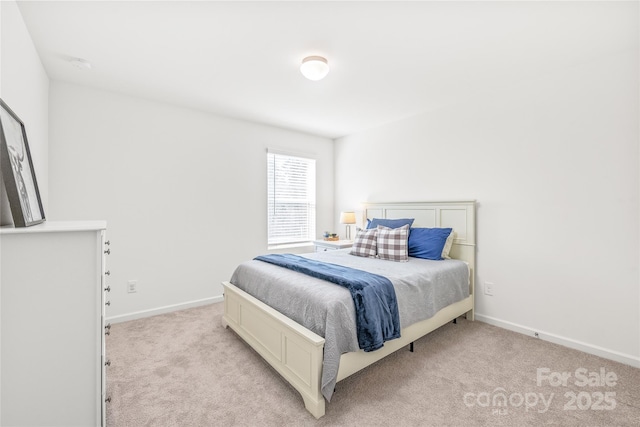 bedroom with baseboards and light colored carpet