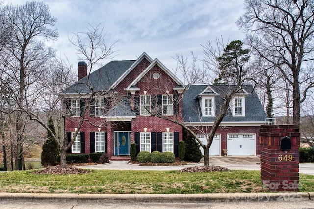 colonial home featuring a garage and a front yard