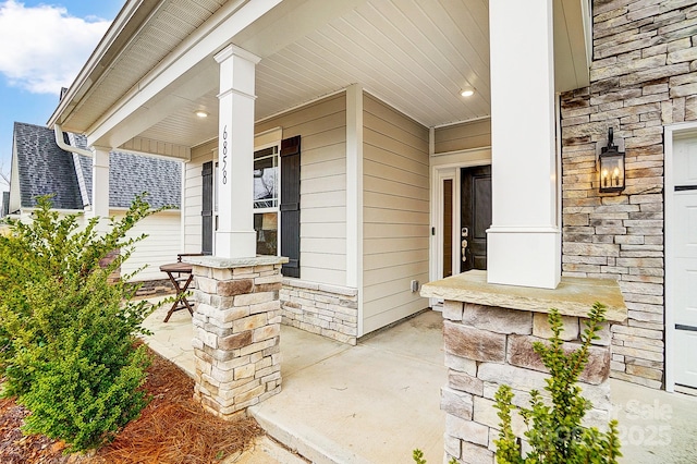 property entrance featuring stone siding and a porch