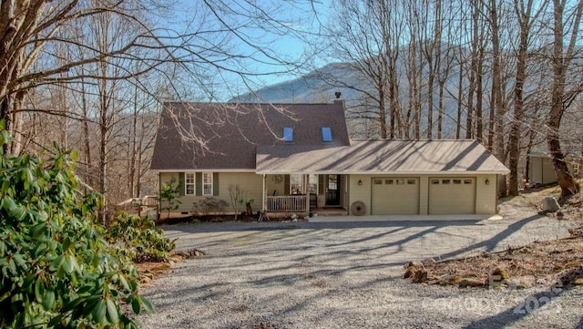 cape cod home with driveway, a chimney, crawl space, covered porch, and an attached garage