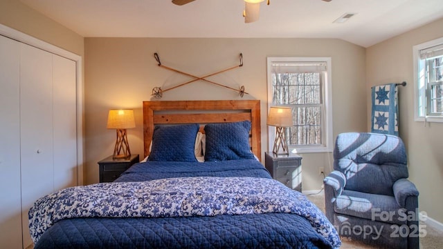 bedroom with lofted ceiling, a closet, visible vents, a ceiling fan, and carpet flooring