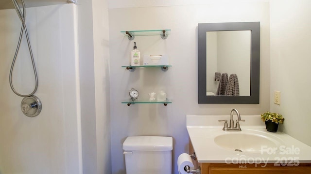 bathroom featuring a shower, vanity, and toilet