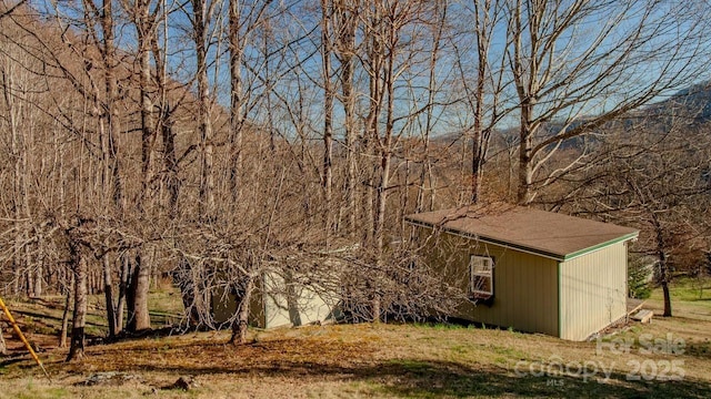 exterior space with an outdoor structure and a forest view