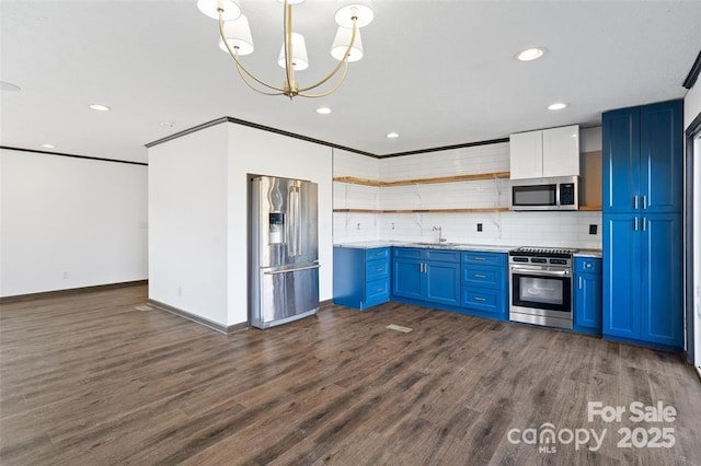 kitchen with blue cabinets, sink, decorative light fixtures, appliances with stainless steel finishes, and backsplash