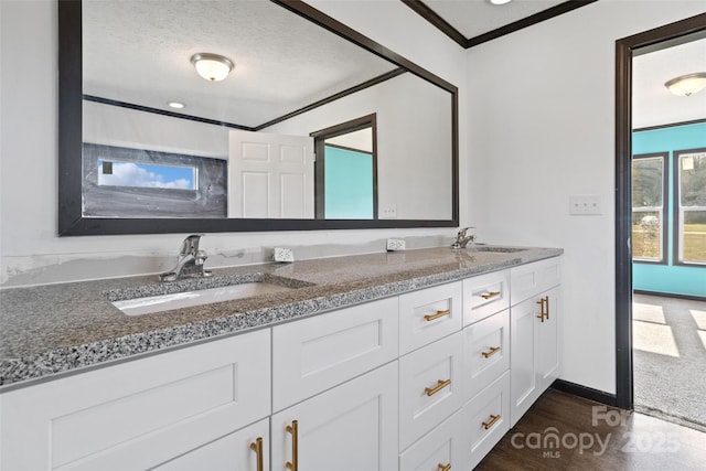 bathroom featuring crown molding, vanity, hardwood / wood-style floors, and a textured ceiling