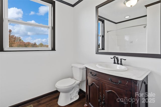 bathroom featuring walk in shower, toilet, crown molding, vanity, and hardwood / wood-style floors